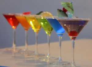 Photo of a row of cocktails in rainbow colours