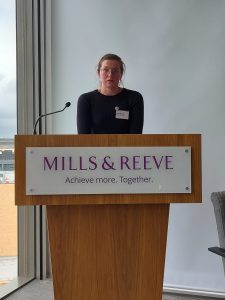 Photo taken at the event showing Holly Redman delivering her keynote talk from the lectern